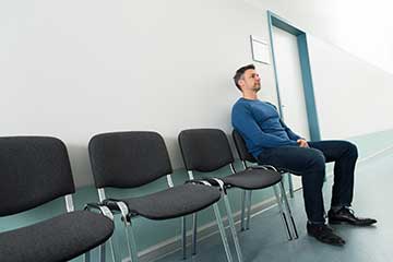 Homme à risque du cancer de la prostate assis seul dans une salle attendant son tour